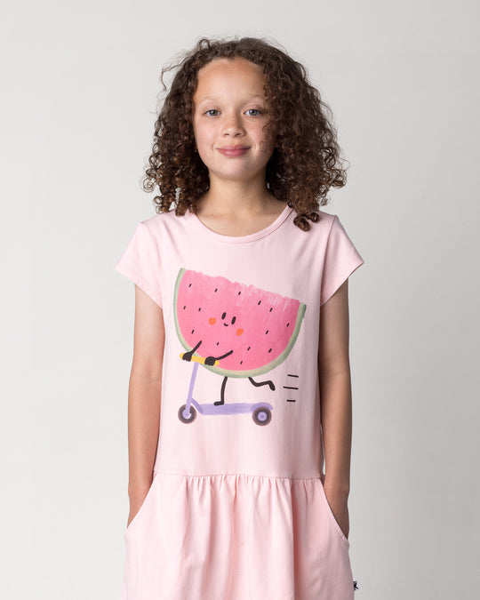 Close up of the Scooting Watermelon Dress in light pink on a kid, front view
