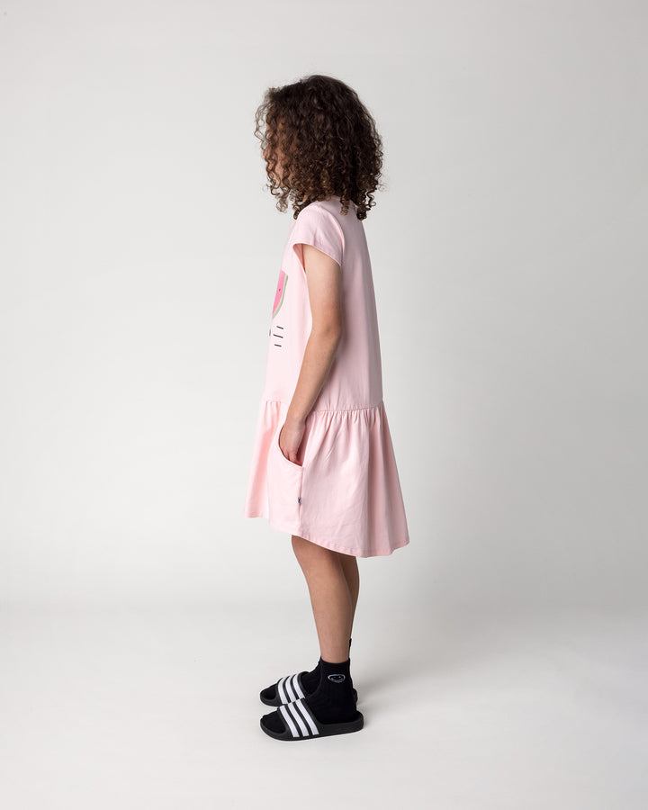Kid wearing the Scooting Watermelon Dress in light pink, side view
