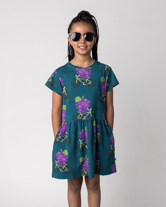Close up of the Biking Grape Dress in dark teal on a kid, front view