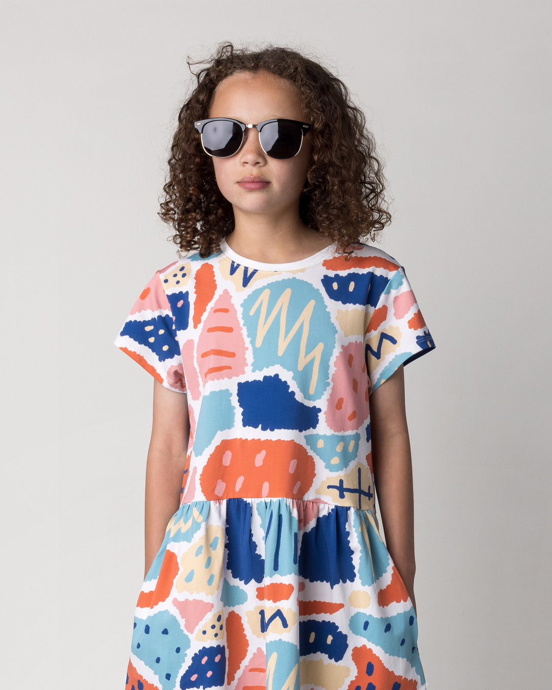 Close up of the Cool Shapes Dress in white on a kid, front view