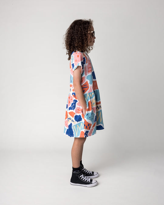 Kid wearing the Cool Shapes Dress in white, side view