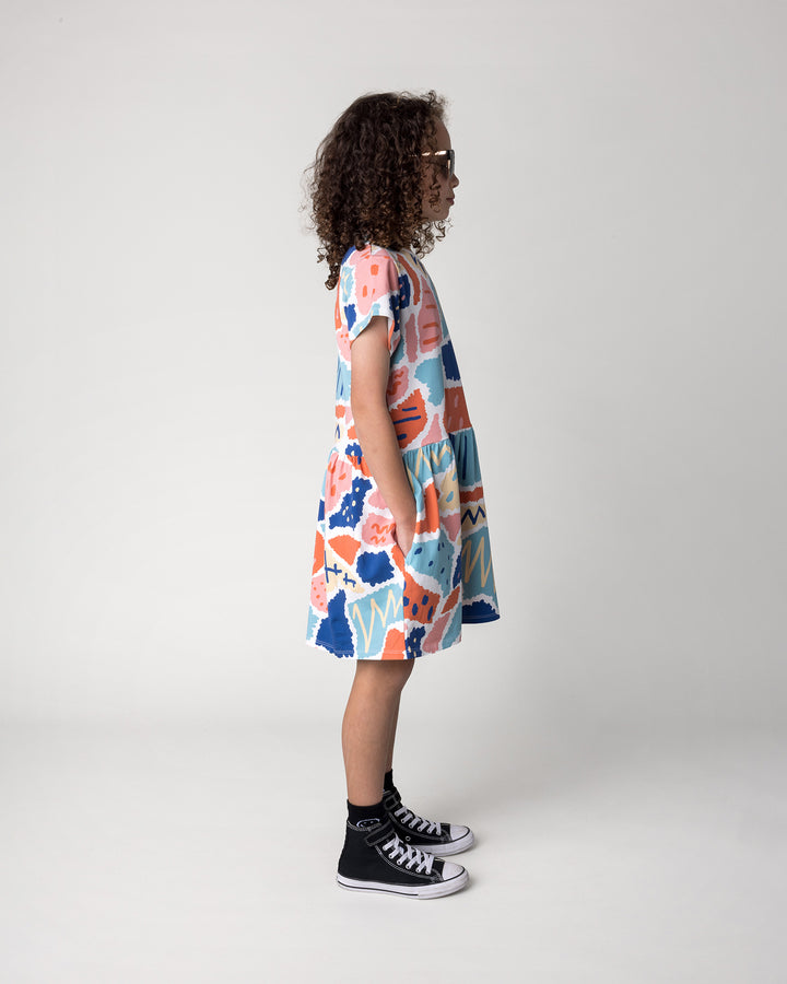 Kid wearing the Cool Shapes Dress in white, side view