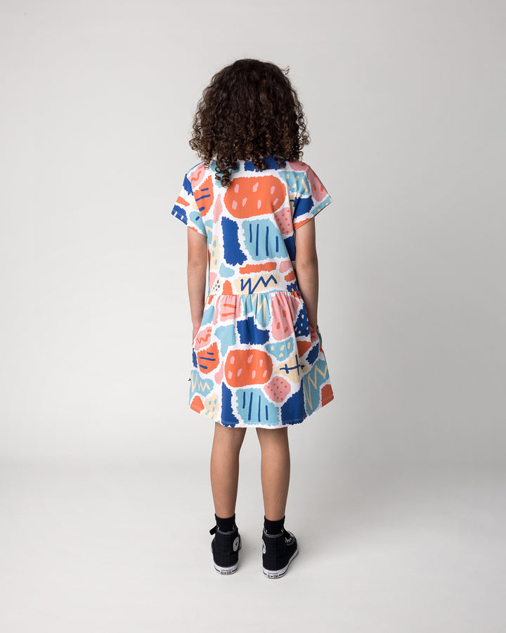 Kid wearing the Cool Shapes Dress in white, back view