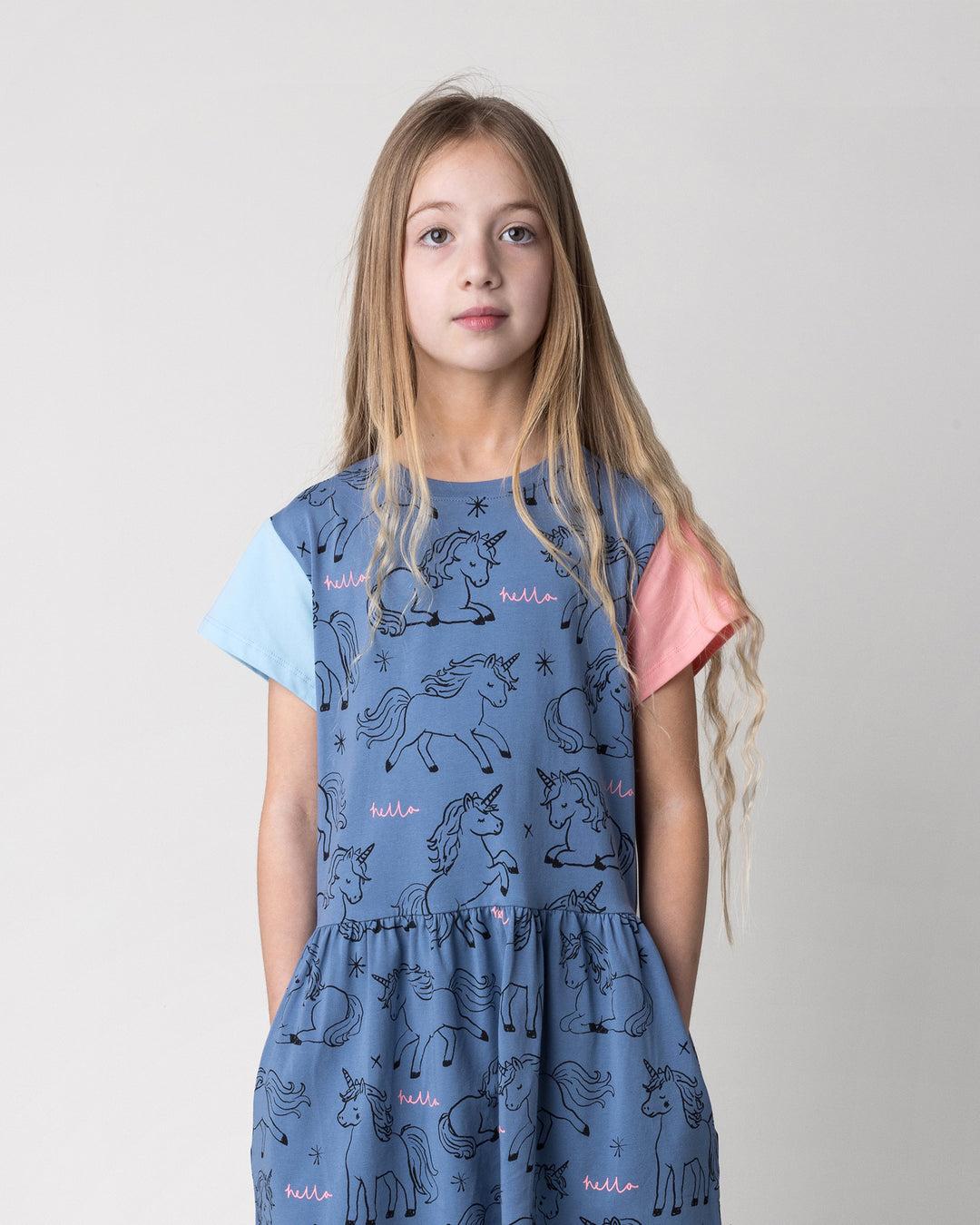 Close up of the Hello Unicorns Dress in mid blue, light blue and pink on a kid, front view