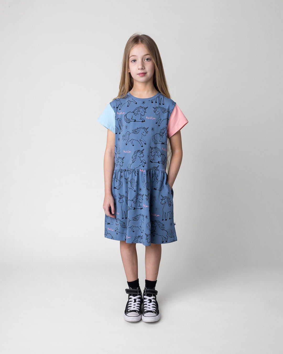 Kid wearing the Hello Unicorns Dress in mid blue, light blue and pink, front view