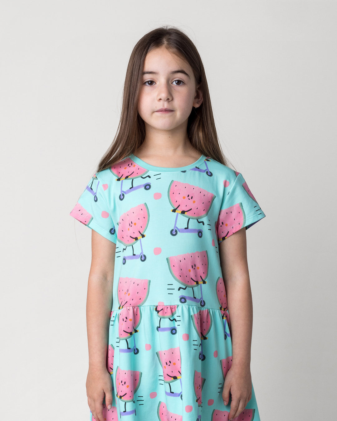Close up of the Scooting Watermelon Dress in light mint on a kid, front view