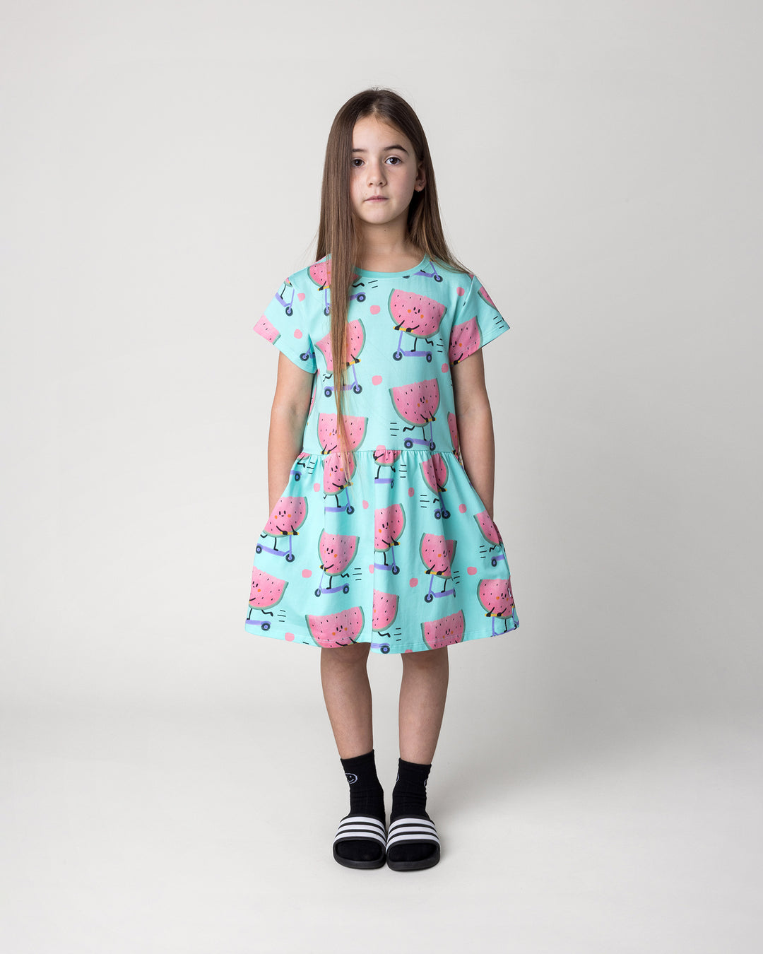 Kid wearing the Scooting Watermelon Dress in light mint, front view