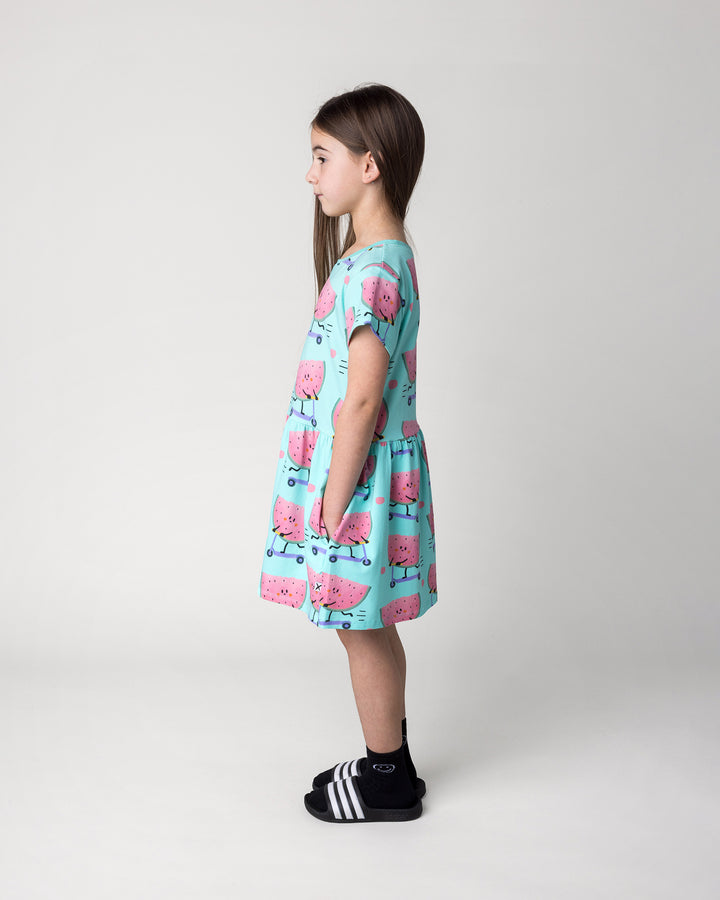 Kid wearing the Scooting Watermelon Dress in light mint, side view