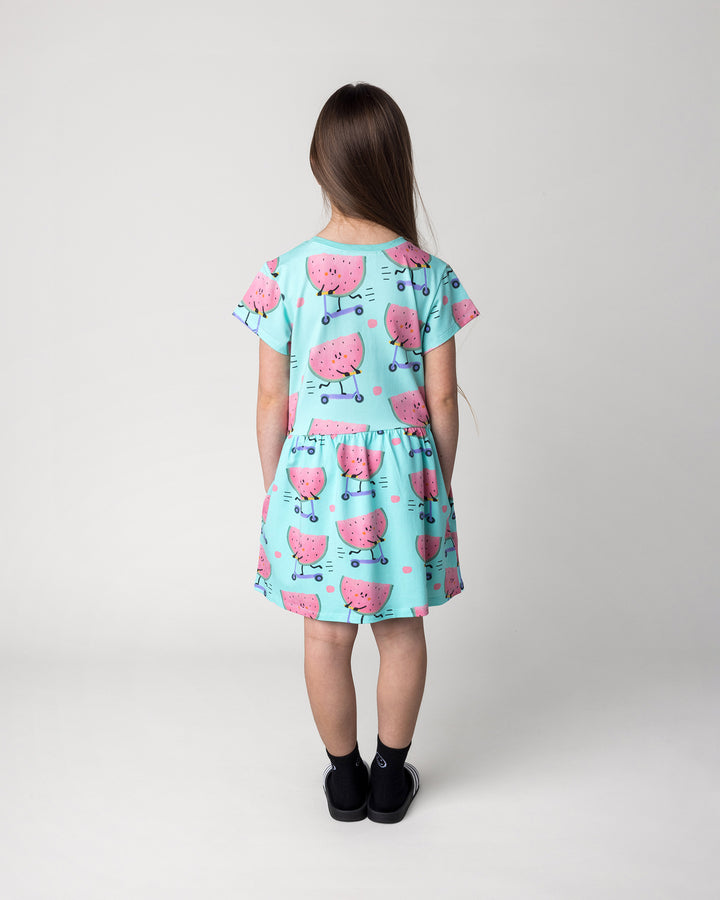 Kid wearing the Scooting Watermelon Dress in light mint, back view