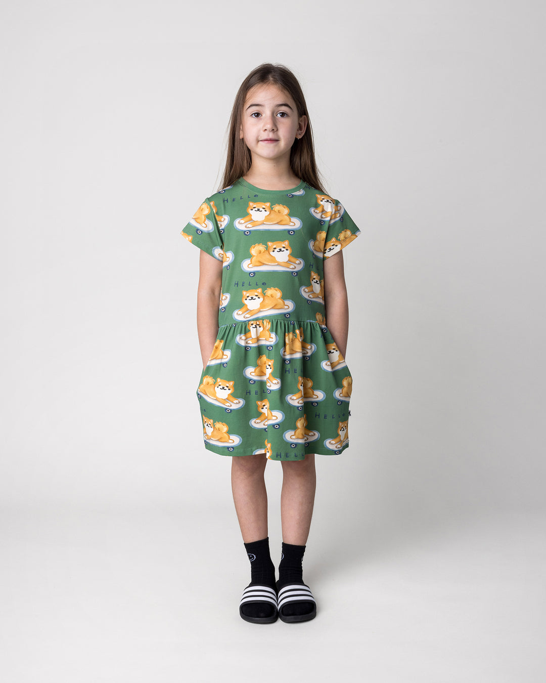 Kid wearing the Skate Puppy Dress in turf, front view