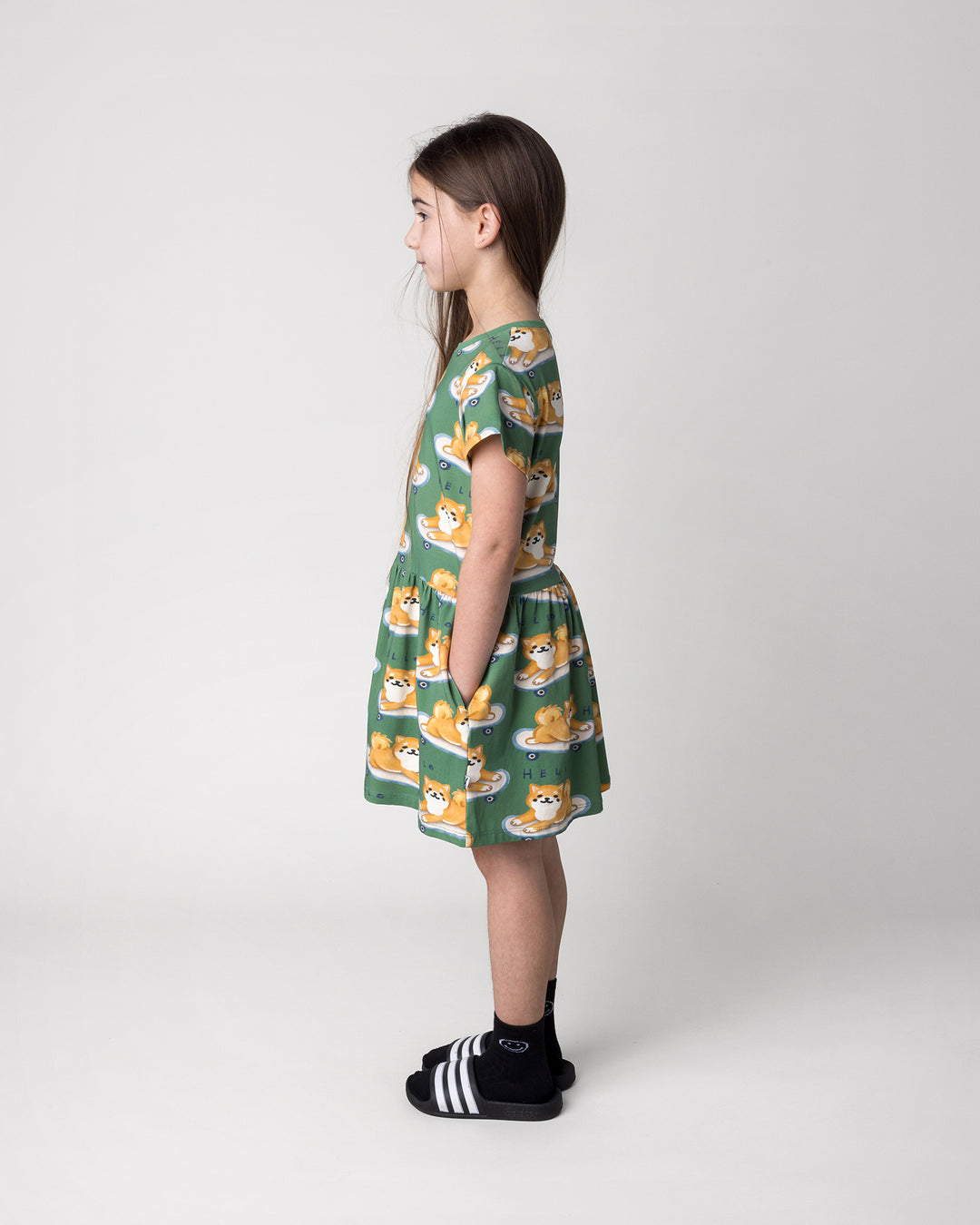 Kid wearing the Skate Puppy Dress in turf, side view