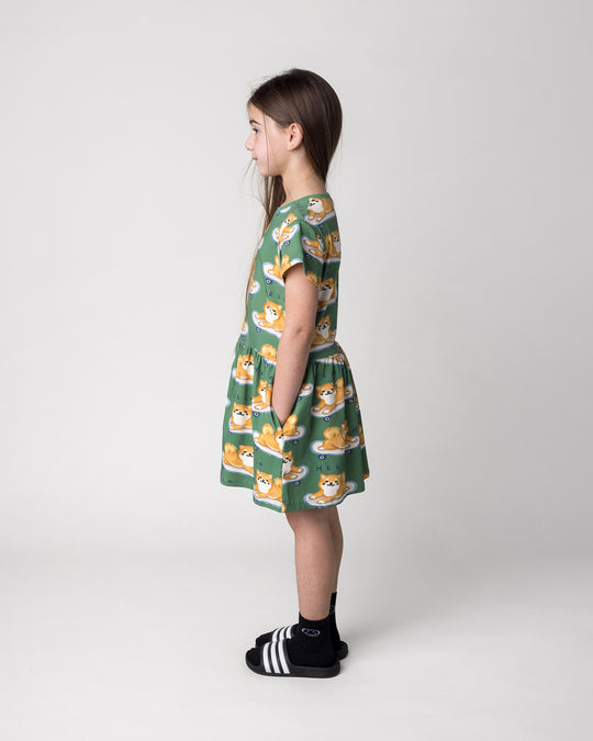 Kid wearing the Skate Puppy Dress in turf, side view