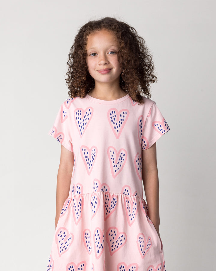 Close up of the Speckle Heart Dress in pink on a kid, front view