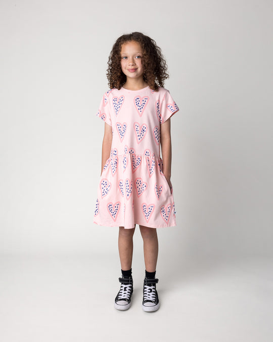 Kid wearing the Speckle Heart Dress in pink, front view