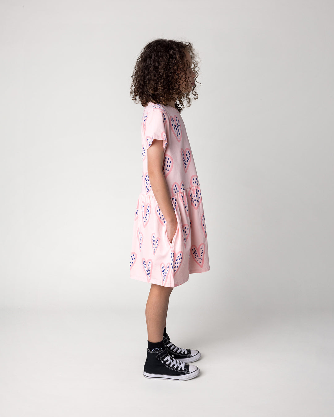 Kid wearing the Speckle Heart Dress in pink, side view