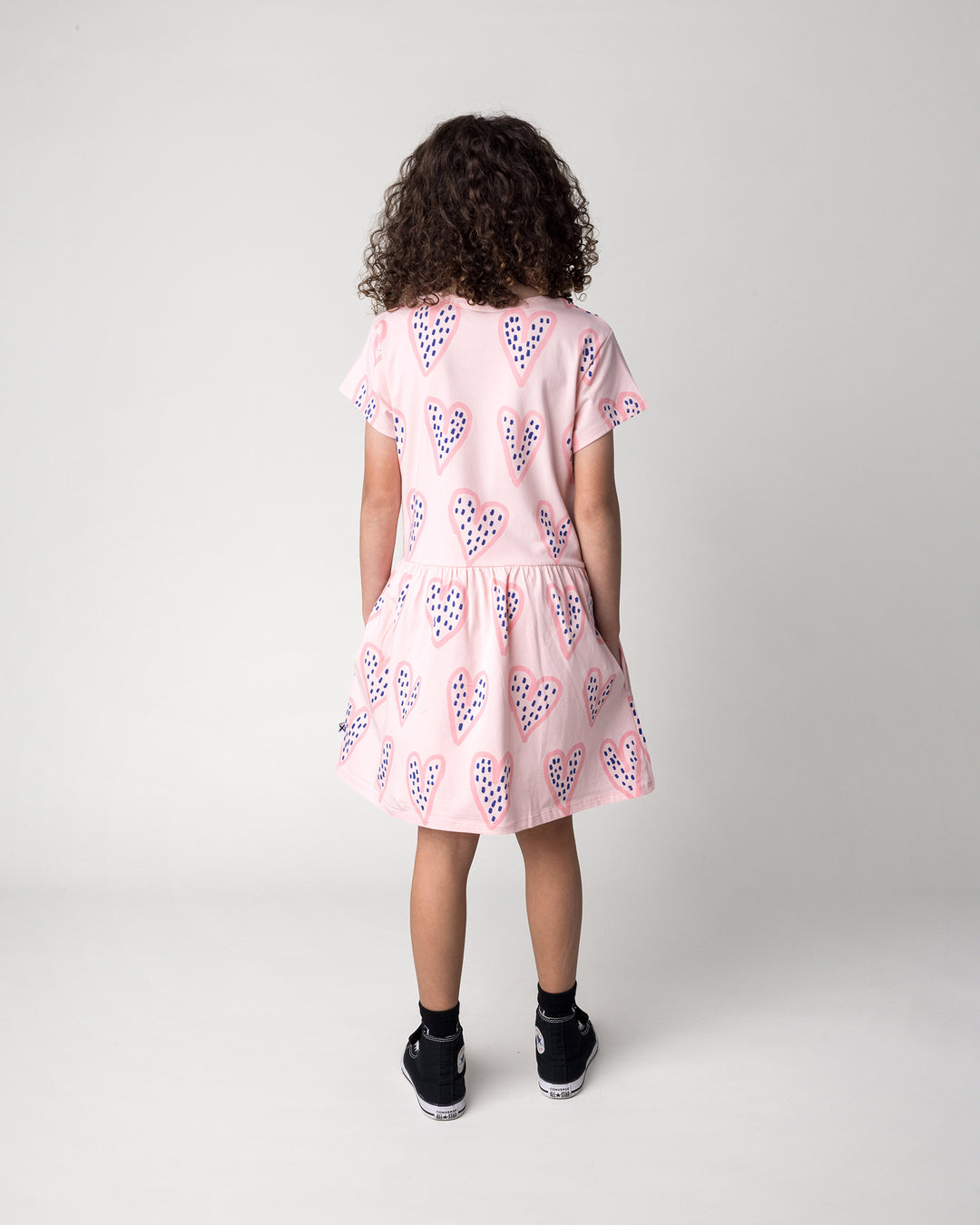 Kid wearing the Speckle Heart Dress in pink, back view