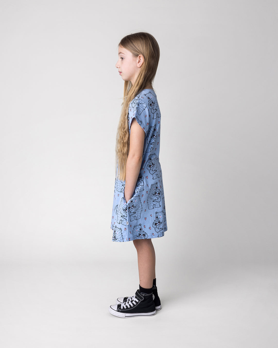 Kid wearing the Bear Hug Dress in blue marle, side view