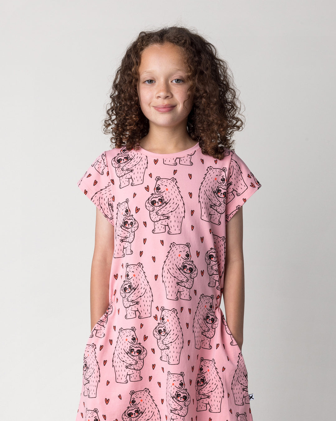 Close up of the Bear Hug Dress in pink on a kid, front view