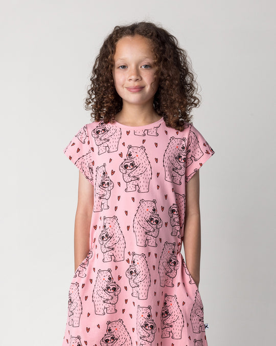 Close up of the Bear Hug Dress in pink on a kid, front view