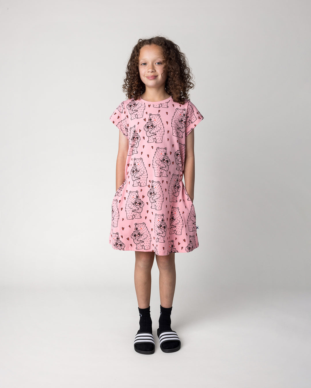 Kid wearing the Bear Hug Dress in pink, front view