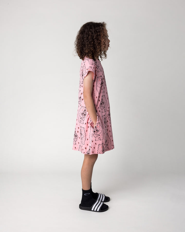 Kid wearing the Bear Hug Dress in pink, side view