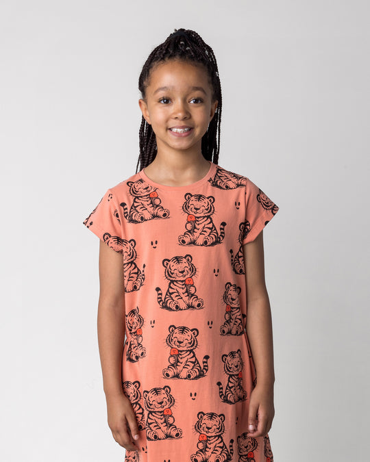 Close up of the Happy Tiger Dress in apricot on a kid, front view