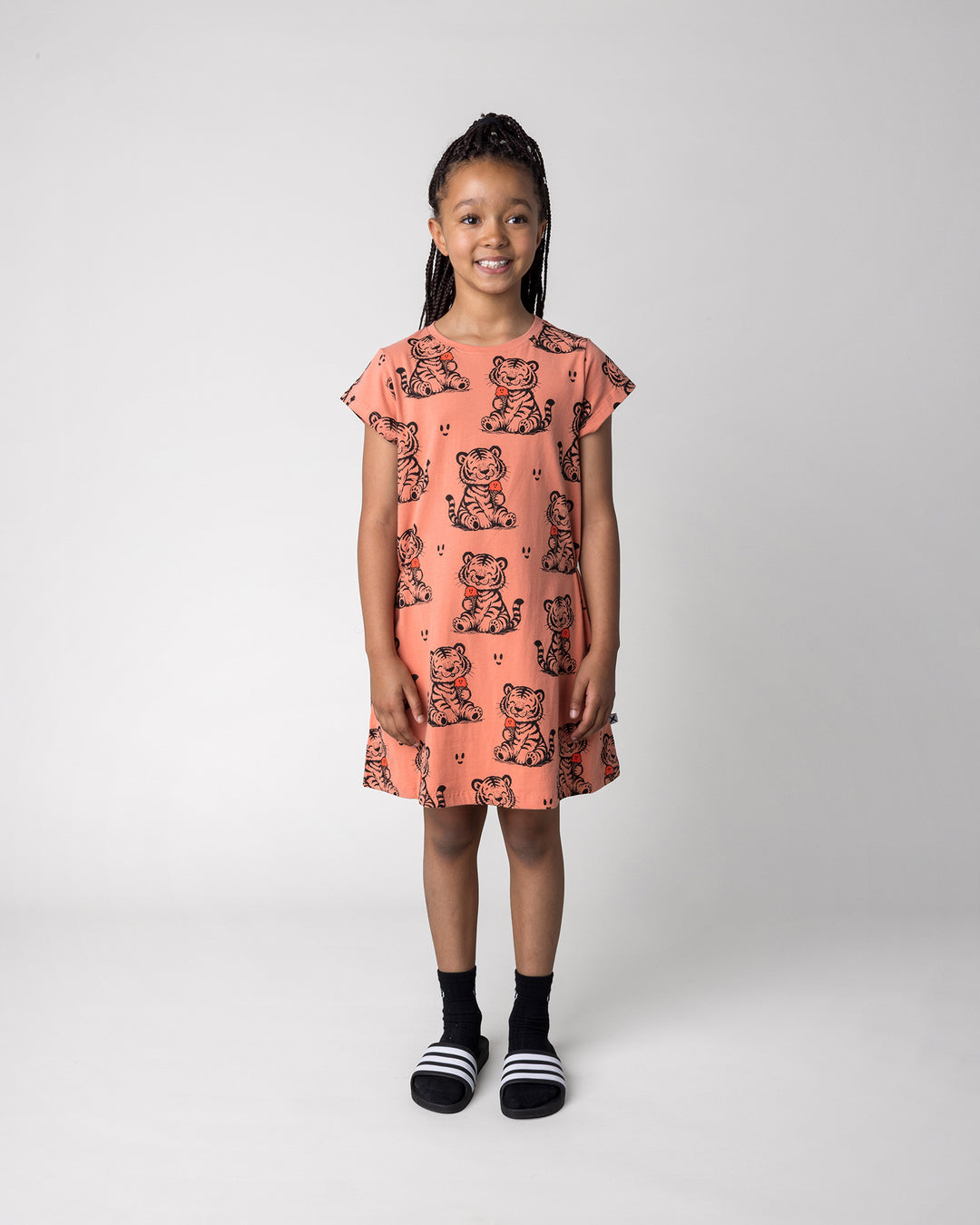 Kid wearing the Happy Tiger Dress in apricot, front view