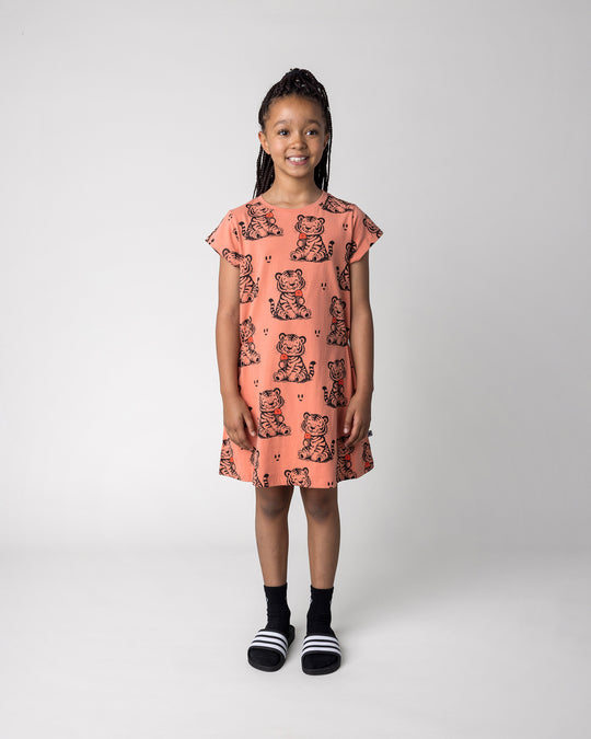 Kid wearing the Happy Tiger Dress in apricot, front view