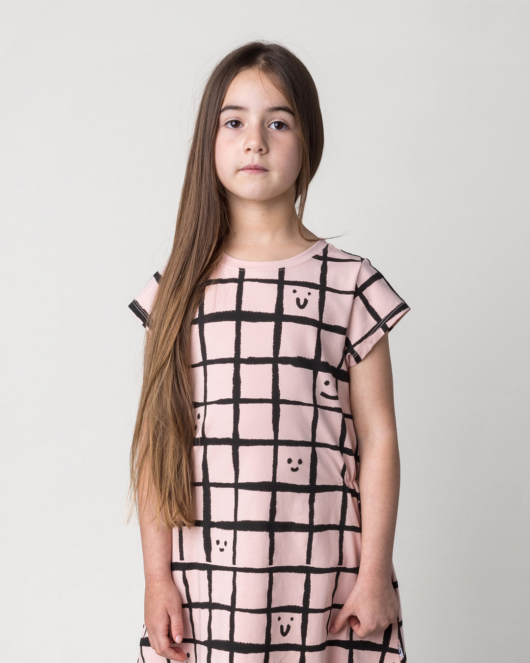 Close up of the Happy Squares Dress in dusty pink on a kid, front view