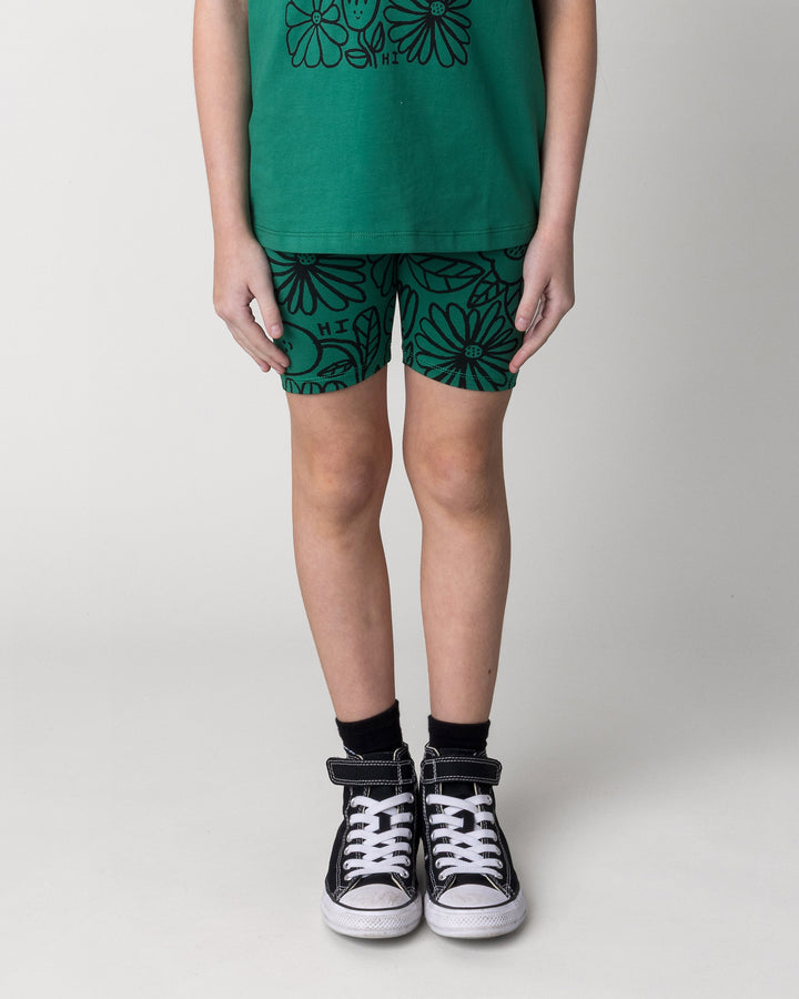 Kid wearing the Big Flowers Bike Pant in kelly green, front view close up