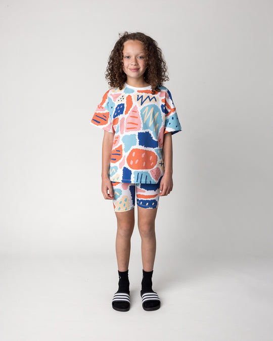 Kid wearing the Cool Shapes Bike Pant in white with the Cool Shapes Tee in white, front view