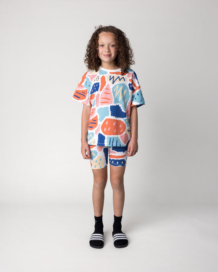 Kid wearing the Cool Shapes Bike Pant in white with the Cool Shapes Tee in white, front view