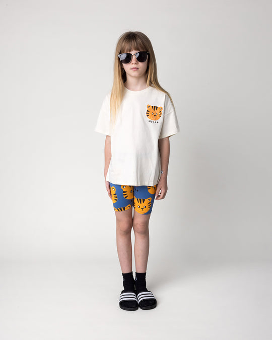 Kid wearing the Hello Tiger Bike Pant in blue with the Hello Tiger Tee in cream, front view