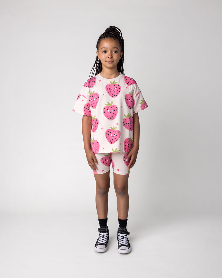 Kid wearing the Happy Strawberry Bike Pant in cream with the Happy Strawberry Tee in cream, front view
