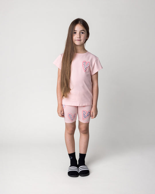 Kid wearing the Speckle Heart Bike Pant in pink with the Speckle Heart Tee in pink, front view