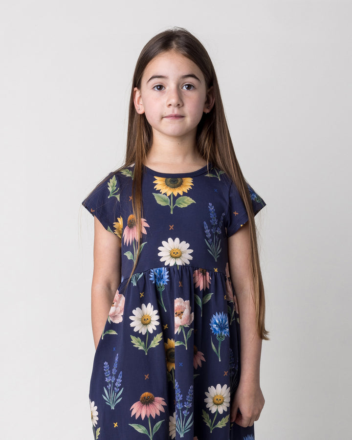 Close up of the Flower Friends Dress in ink on a kid, front view