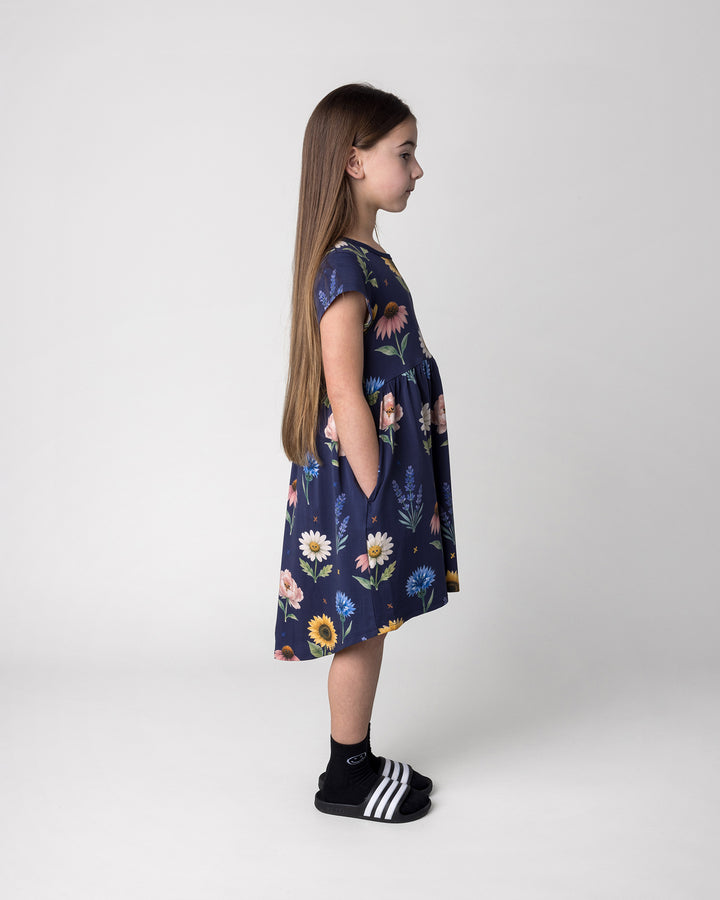 Kid wearing the Flower Friends Dress in ink, side view