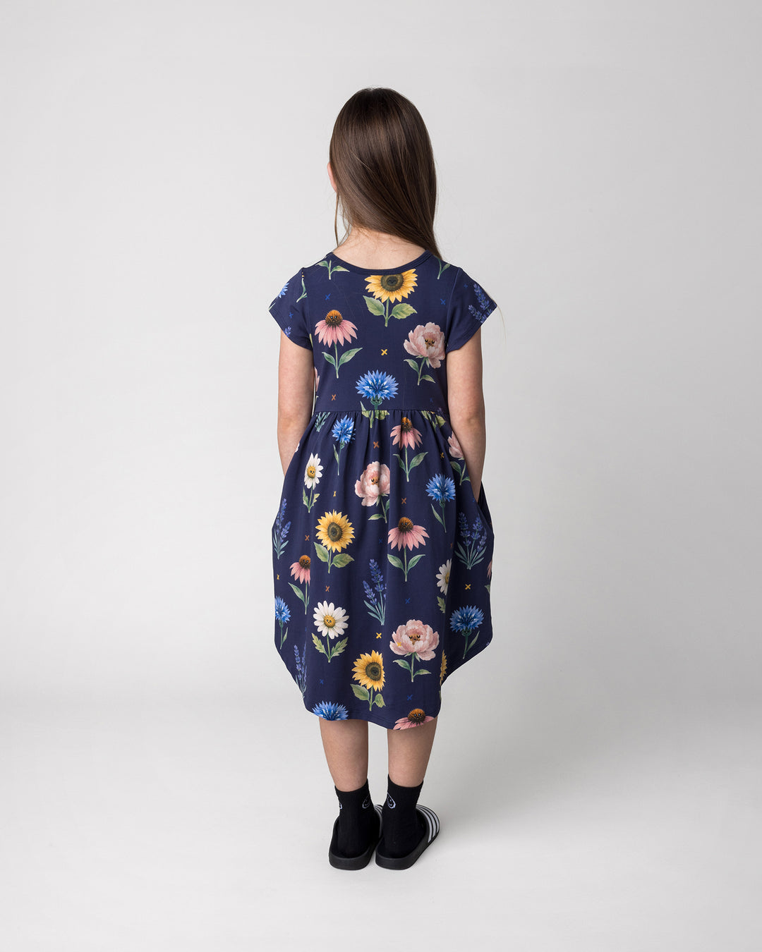 Kid wearing the Flower Friends Dress in ink, back view