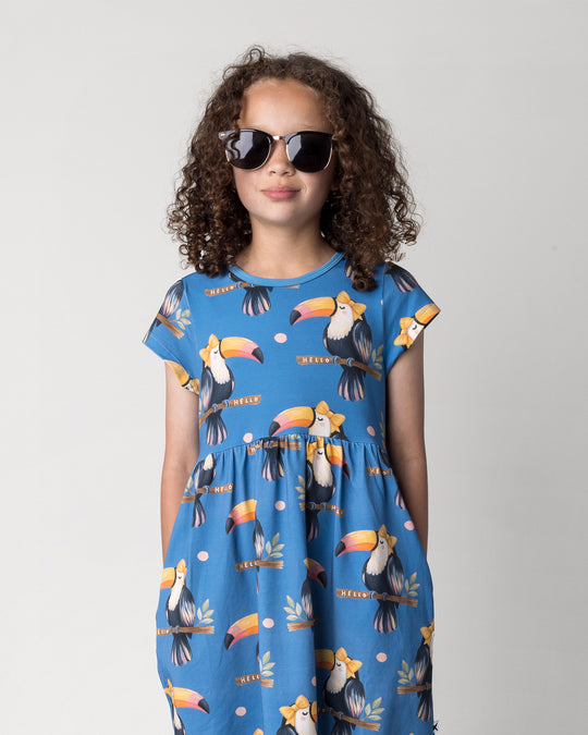 Close up of the Hello Toucan Dress in aqua on a kid, front view