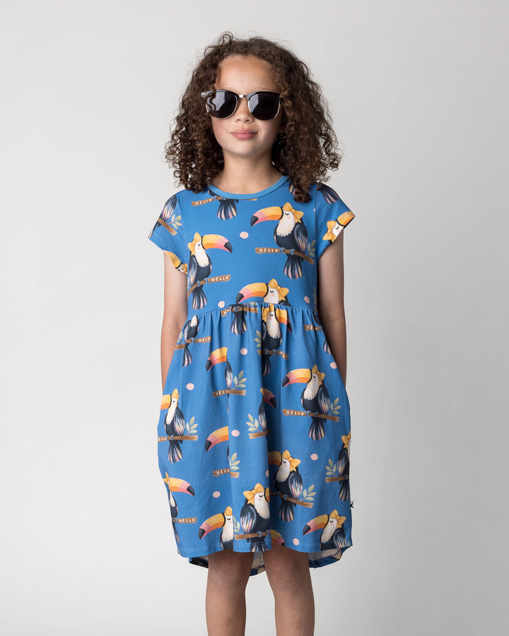 Close up of the Hello Toucan Dress in aqua on a kid, front view