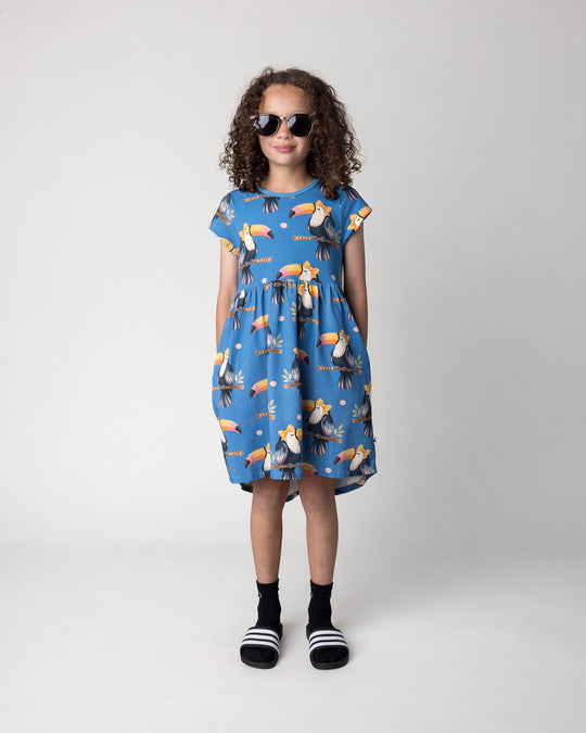 Kid wearing the Hello Toucan Dress in aqua, front view