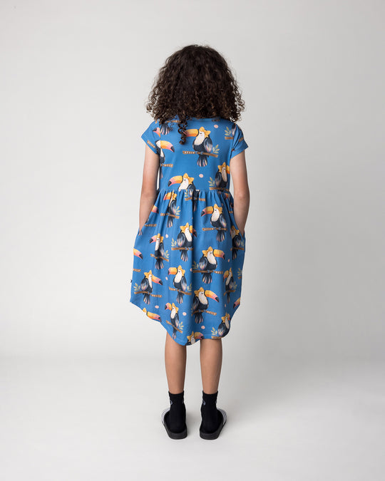 Kid wearing the Hello Toucan Dress in aqua, back view