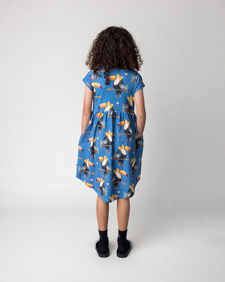 Kid wearing the Hello Toucan Dress in aqua, back view