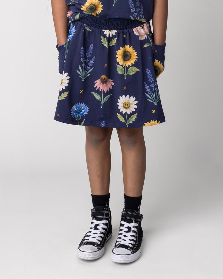 Kid wearing the Flower Friends Skirt in ink, front view close up
