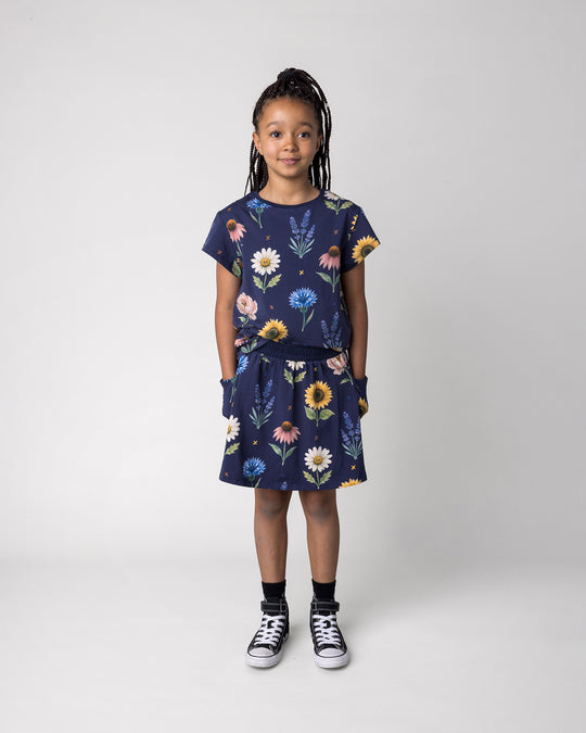 Kid wearing the Flower Friends Skirt in ink with the Flower Friends Tee in ink, front view