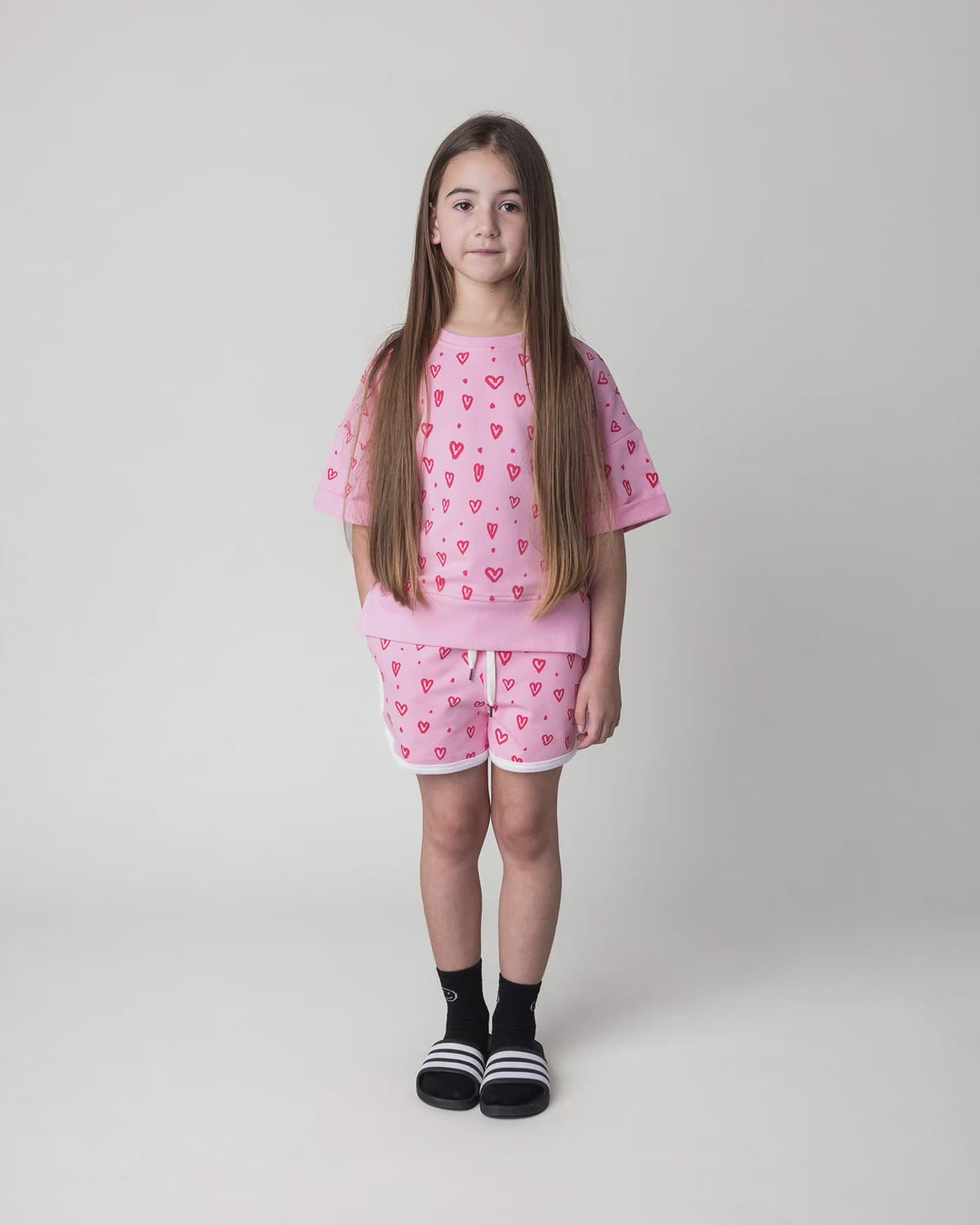 Kid wearing the Hearts Short in pink and white, full circle video