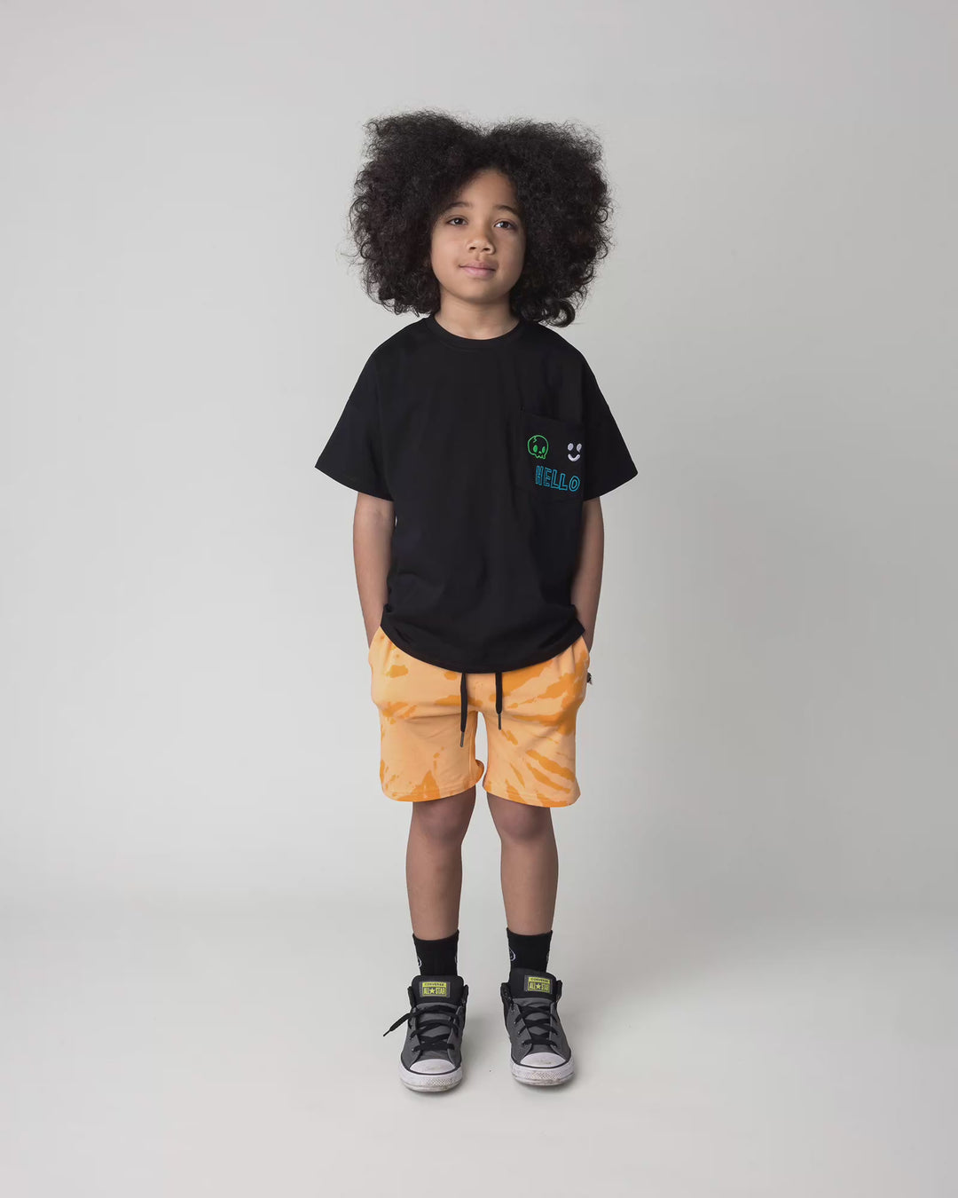Kid wearing the Badges Tee in black, full circle video