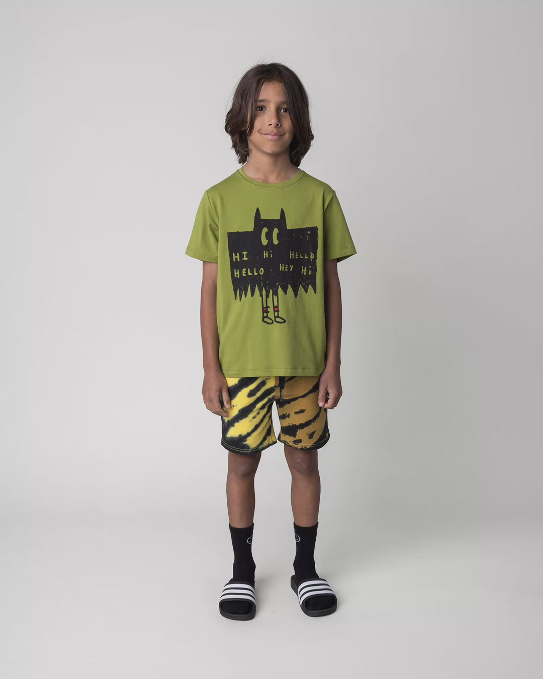 Kid wearing the Greetings Bat Tee in olive, full circle video