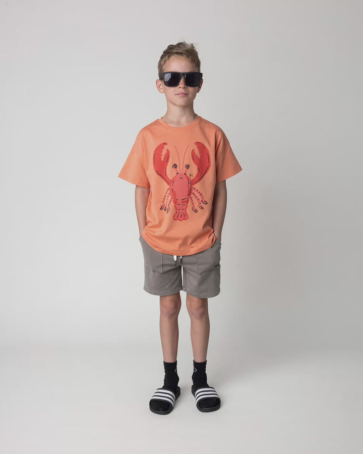 Kid wearing the Vacay Crayfish Tee in light orange, full circle video