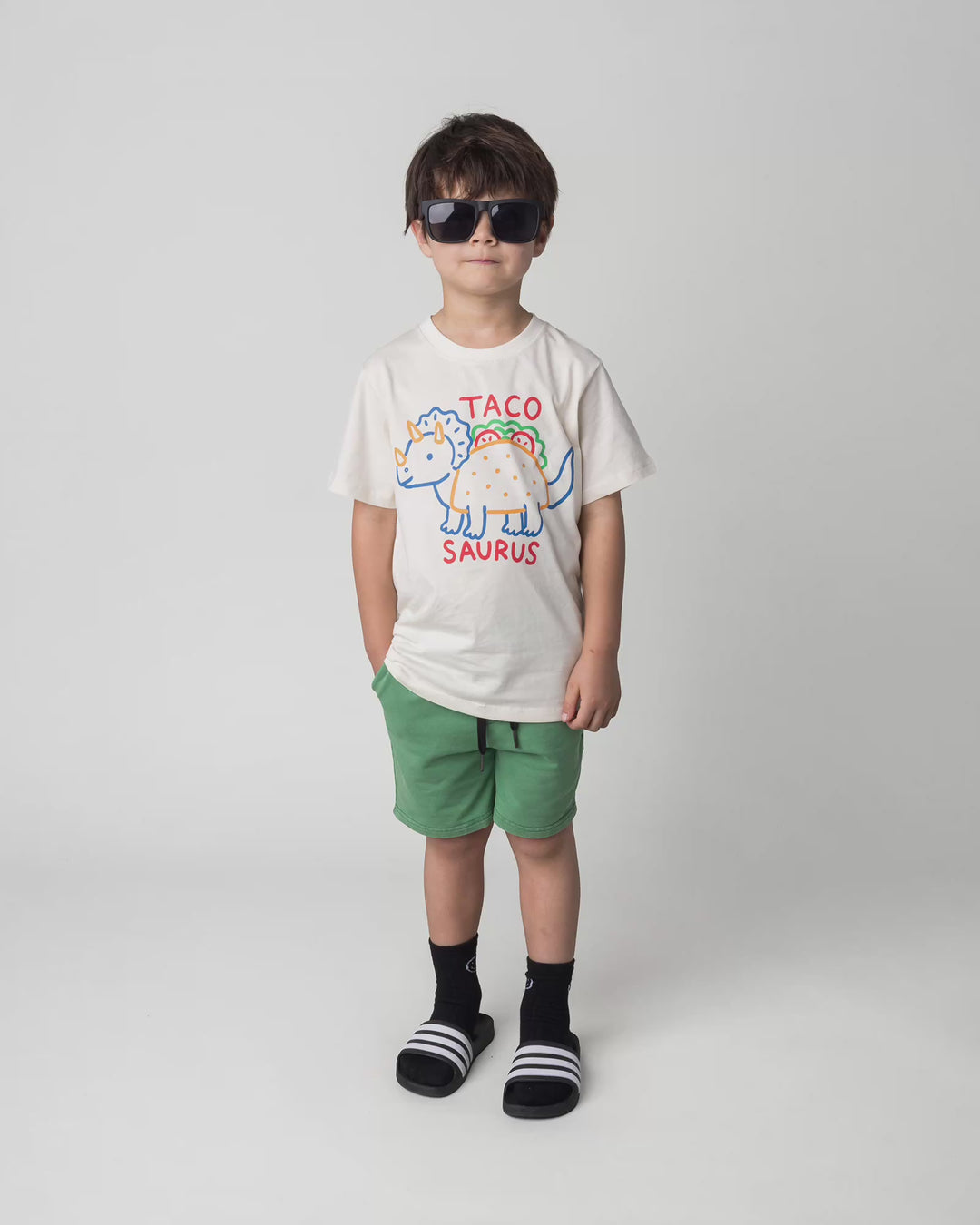 Kid wearing the Taco Saurus Tee in cream, full circle video